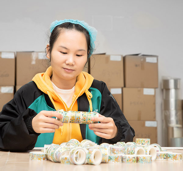 a worker does full inspection on washi tape before shipment
